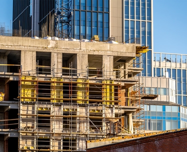 A large building under construction, with scaffolding and a crane.