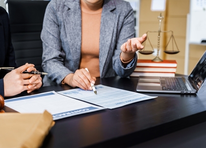 lawyers in business suits meet at wooden desk, over contract paper