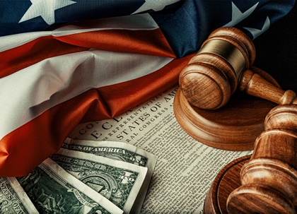 A wooden gavel, legal documents, and part of a flag are visible.