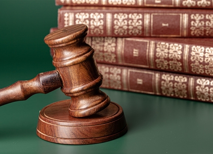 Close up of a brown wooden gavel and book