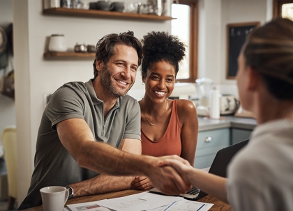 A couple is shaking hands with a woman.
