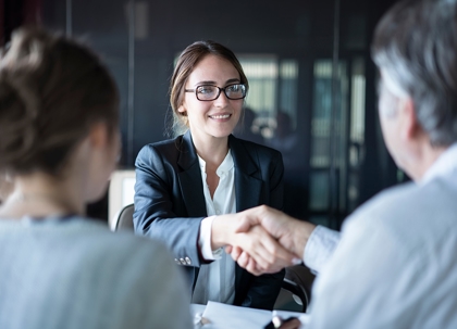 A man and woman are shaking hands with other woman.
