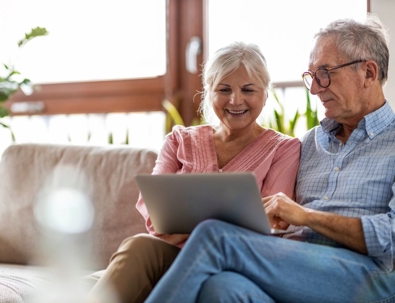 a man and woman discussing while looking at a laptop