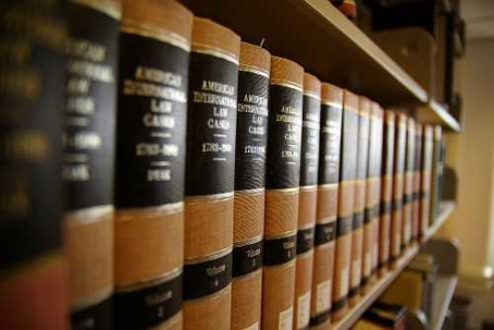 Many law books are lined up on a shelf.